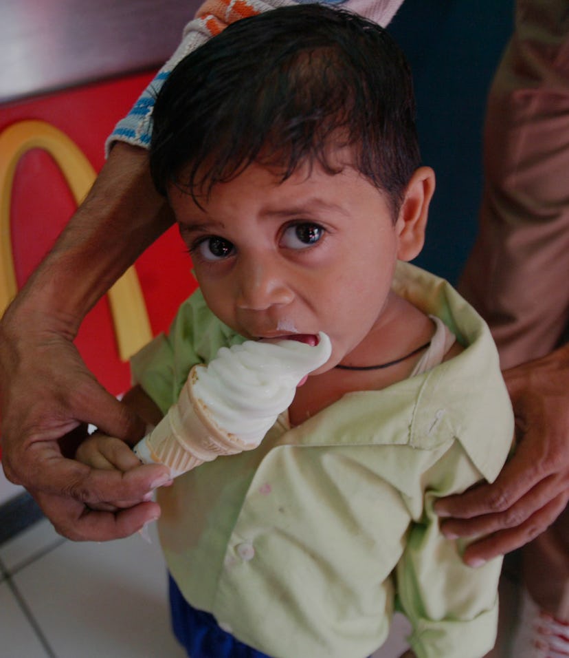 A Child eating ice cream at a McDonalds outlet, India. (Photo by: Salman Quraishi/IndiaPictures/Univ...