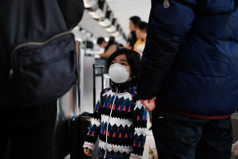 NEW YORK, NEW YORK - JANUARY 31: At the terminal that serves planes bound for China, a child wears a...