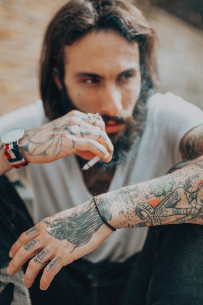 hipster man with tattoo smoking