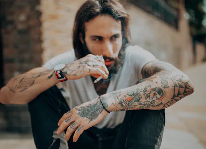 hipster man with tattoo smoking