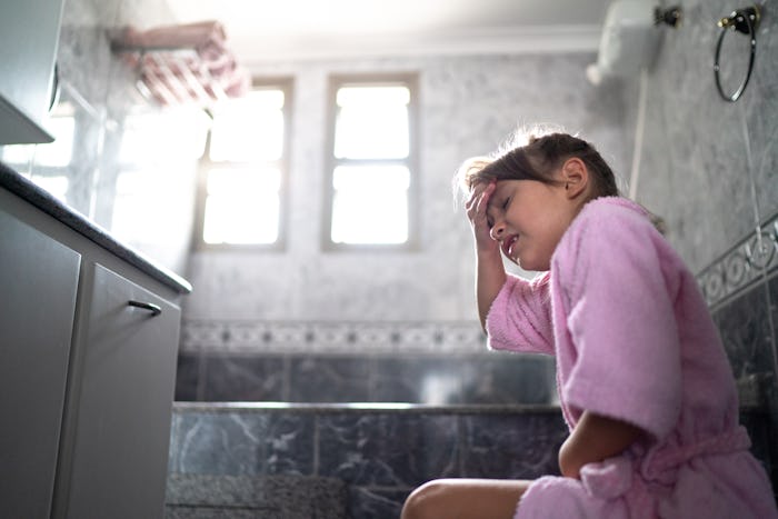 Girl with stomachache using the toilet at home