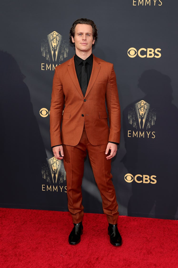 Jonathan Groff in an orange suit and a black shirt at the Emmys Red Carpet 2021