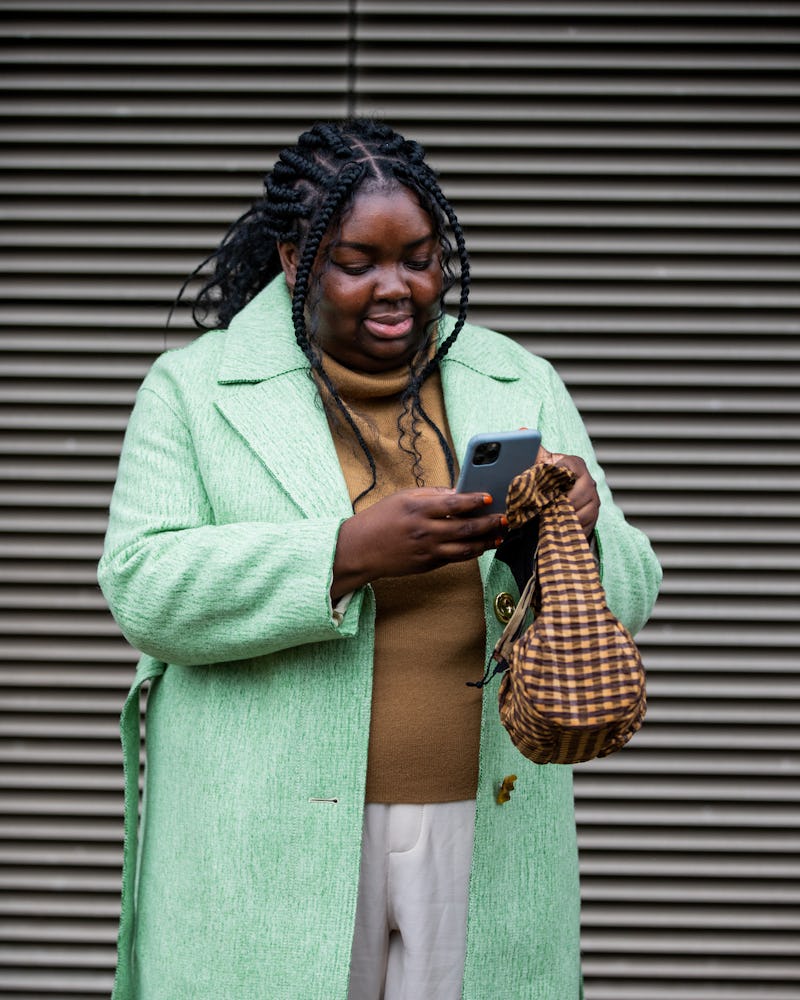 A brown turtleneck sweater outfit with a colorful coat. 