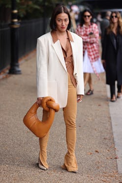 LONDON, ENGLAND - SEPTEMBER 20: Guest wearing white jacket, pretzel bag attends ROKSANDA at the Serp...