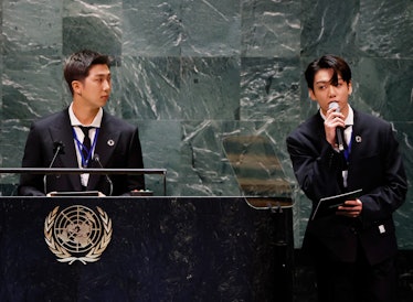 NEW YORK, NEW YORK - SEPTEMBER 20: RM listens as Jungkook of the South Korean boy band BTS speaks at...