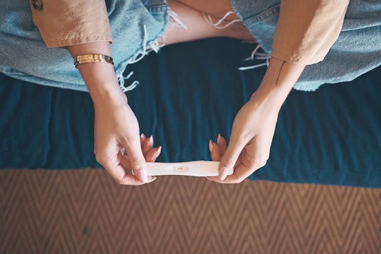 A pair of hands holding an at-home pregnancy test