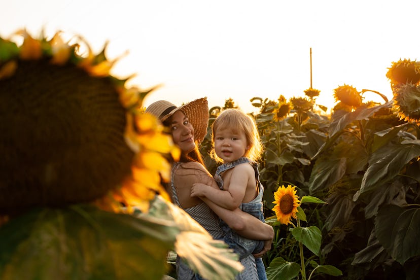 baby and mom in sunflower field