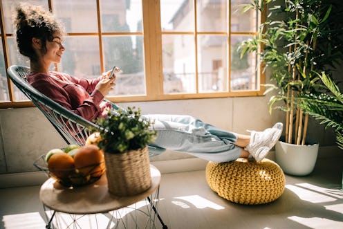 A woman sitting in a chair next to a window screen records someone's Instagram story. Does Instagram...