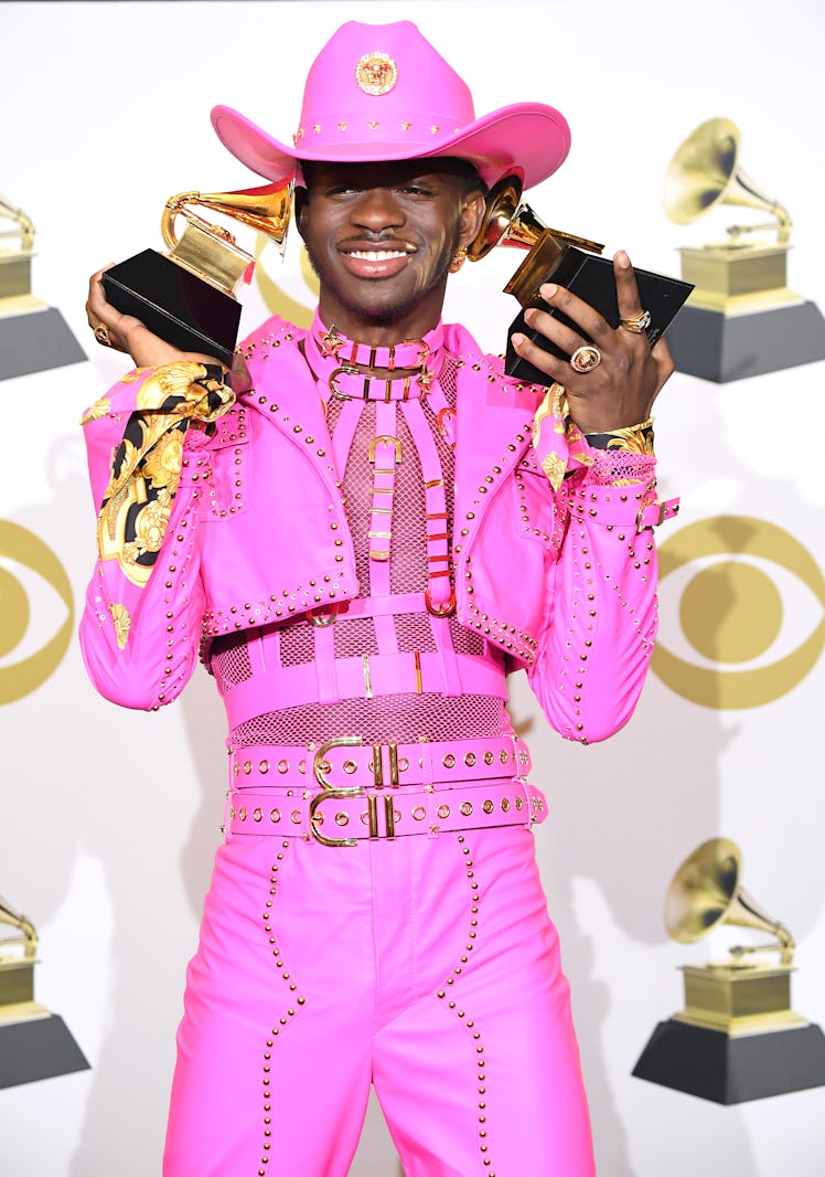 Lil Nas X poses at the 62nd Annual GRAMMY Awards wearing a pink, leather cowboy look.