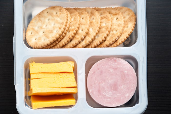 Plastic tray containing sliced honey ham,cheddar cheese, and crackers from above