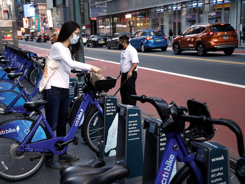 NEW YORK, NEW YORK - NOVEMBER 09: A woman wearing a protective mask places her groceries on a CitiBi...