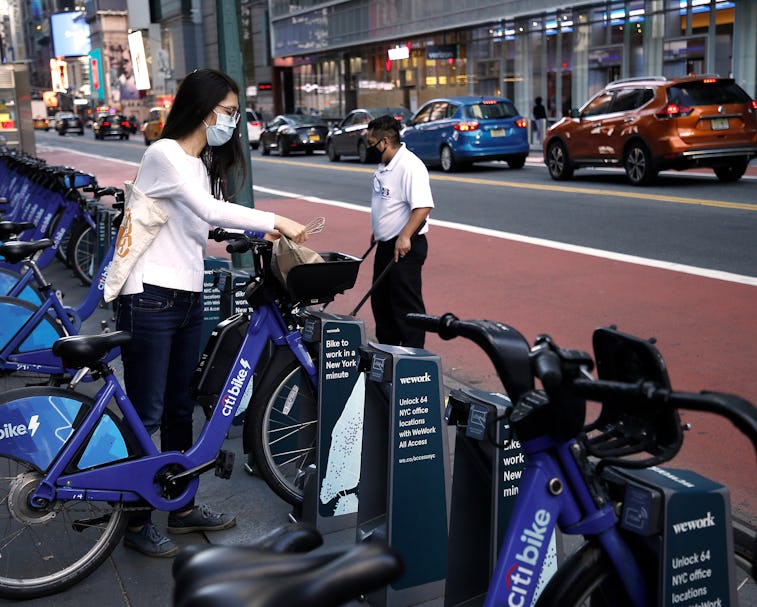 NEW YORK, NEW YORK - NOVEMBER 09: A woman wearing a protective mask places her groceries on a CitiBi...