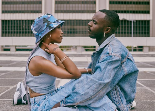 Shot of a trendy young couple sitting face to face against an urban background