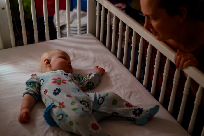 baby sleeping in crib, mom looking at baby