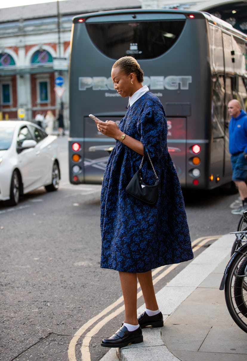 LONDON, ENGLAND - SEPTEMBER 20: A guest is seen wearing navy dress, Prada bag outside Simone Rocha d...