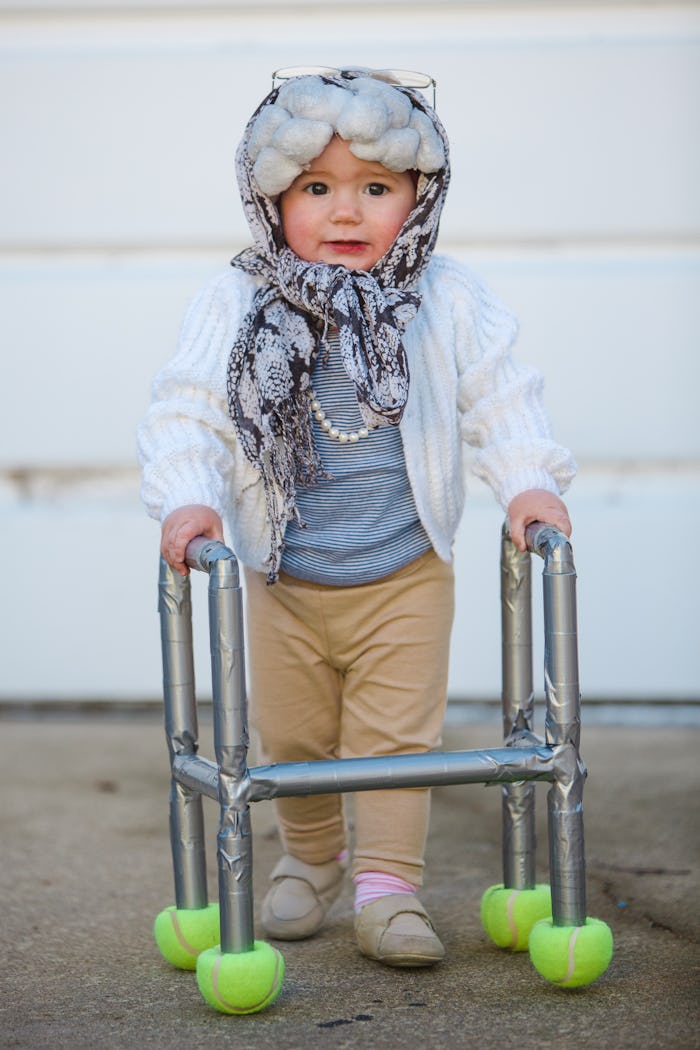 a baby girl dressed up as an old lady for Halloween.