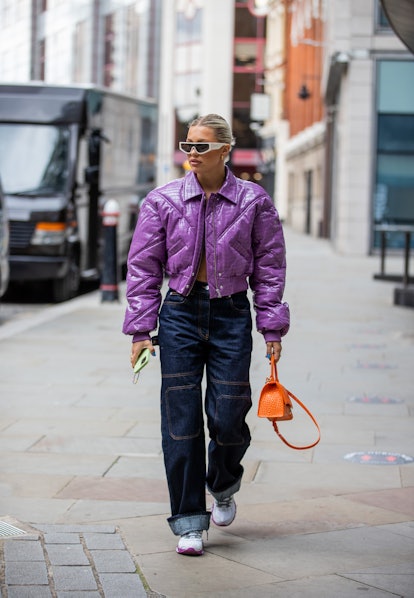 LONDON, ENGLAND - SEPTEMBER 17: A guest is seen wearing purple cropped jacket, orange Balenciaga bag...