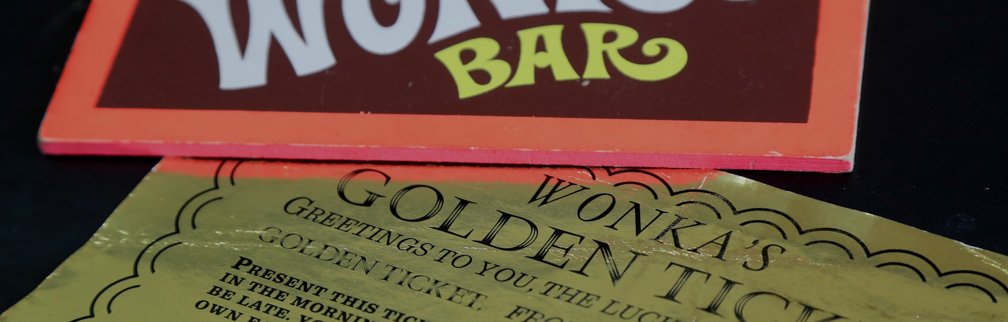 Two of the most iconic film props - a Golden Ticket and Wonka Bar from the 1971 film Willy Wonka & t...