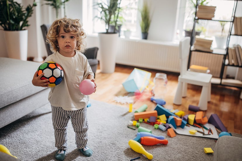 cute little boy playing alone in living room at home.