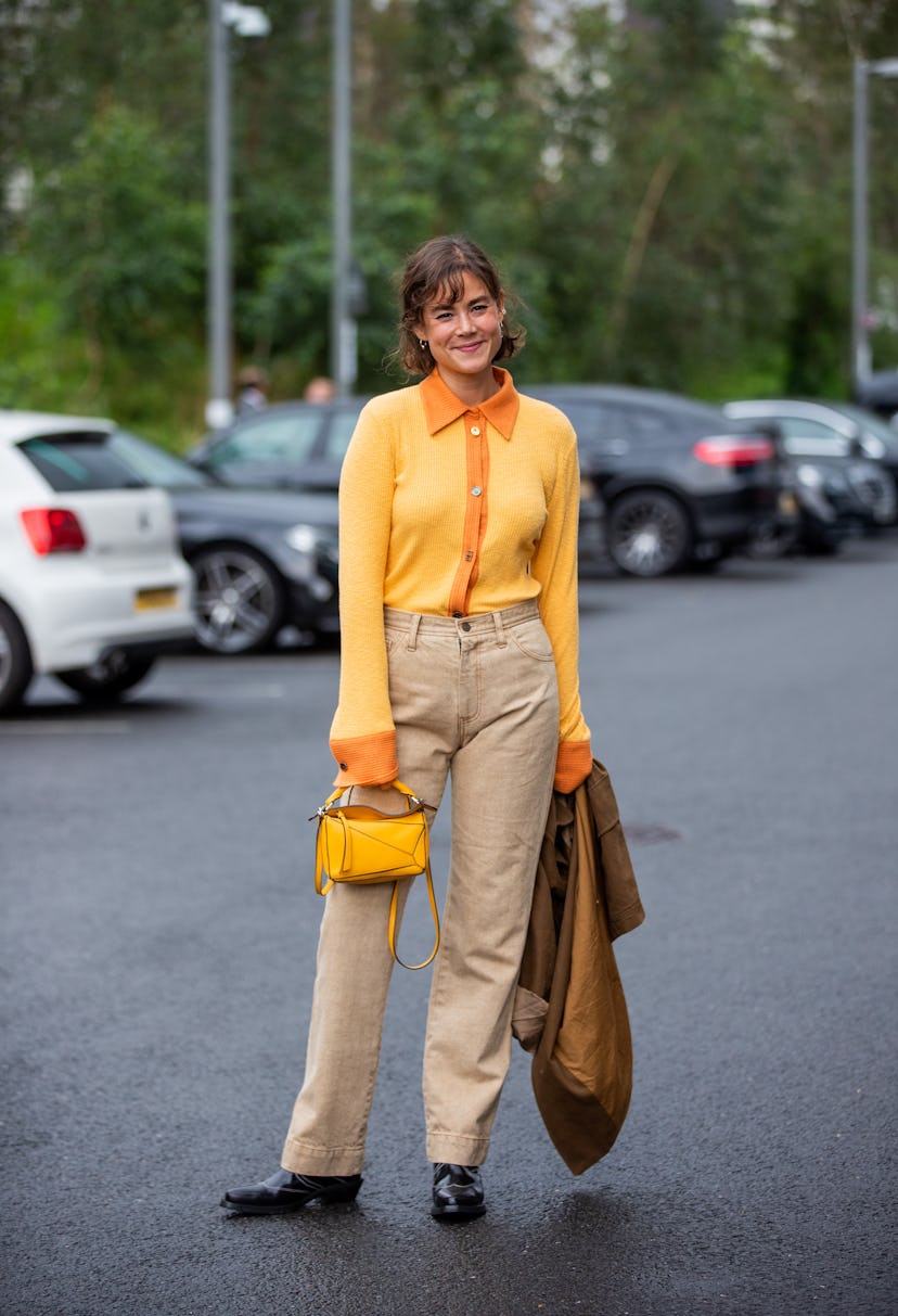 LONDON, ENGLAND - SEPTEMBER 19: A guest is seen wearing yellow Loewe bag outside Rejina Pyo during L...