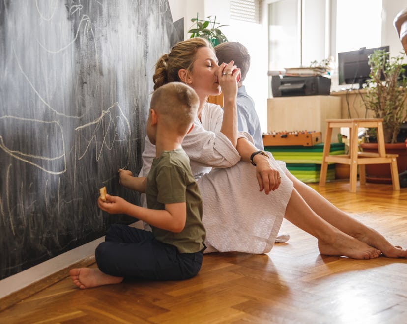 Full length shot of two little boys sitting on the floor and drawing with chalk on a blackboard wall...