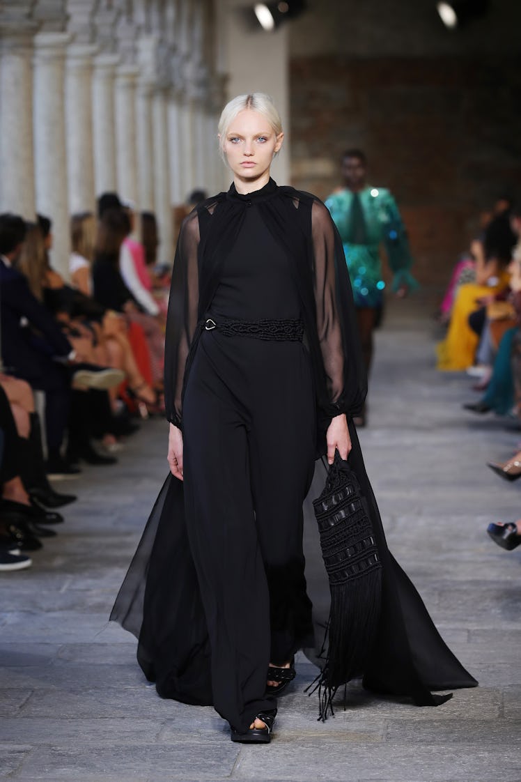 A model on the runway at the Alberta Ferretti fashion show during Milan Fashion Week in a black gown...