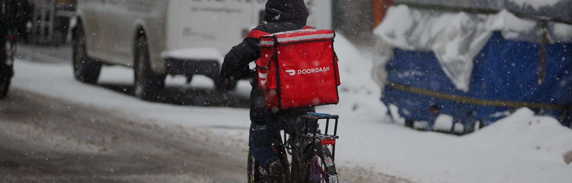 NEW YORK, USA - FEBRUARY 18: A food delivery guy with bicycle is seen as snowfall blankets the Times...