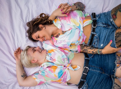 Directly above photo of a young lesbian couple. They are lying on the picnic blanket
