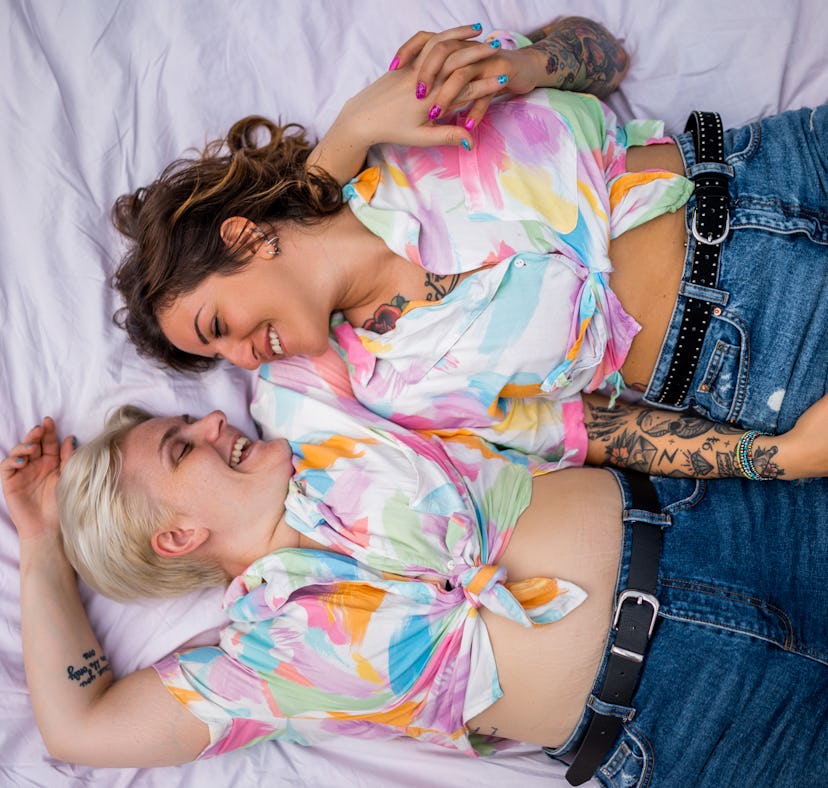 Directly above photo of a young lesbian couple. They are lying on the picnic blanket