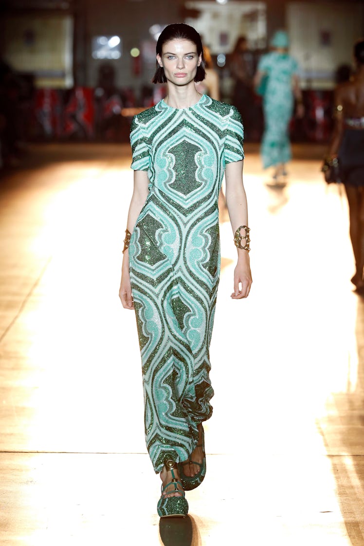 A model at the Etro fashion show at Milan Fashion Week Spring 2022 in a floor-length green and turqu...