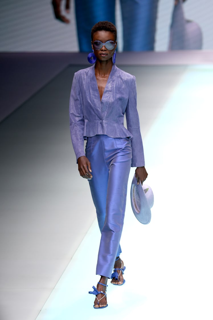 A model at the Emporio Armani fashion show at Milan Fashion Week in a light grey blouse with ruffles...