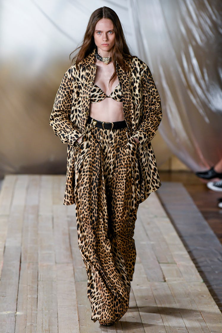 A model walking the Roberto Cavalli show at Milan Fashion Week Spring 2022 in a leopard-print pants,...