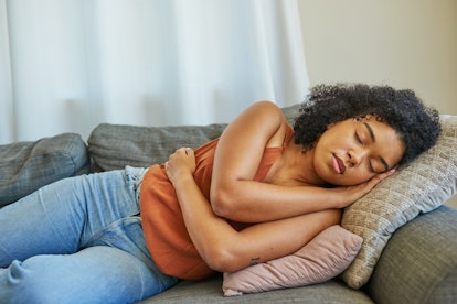 Shot of a young woman sleeping on a sofa at home. Craving meat? You might need the extra energy.