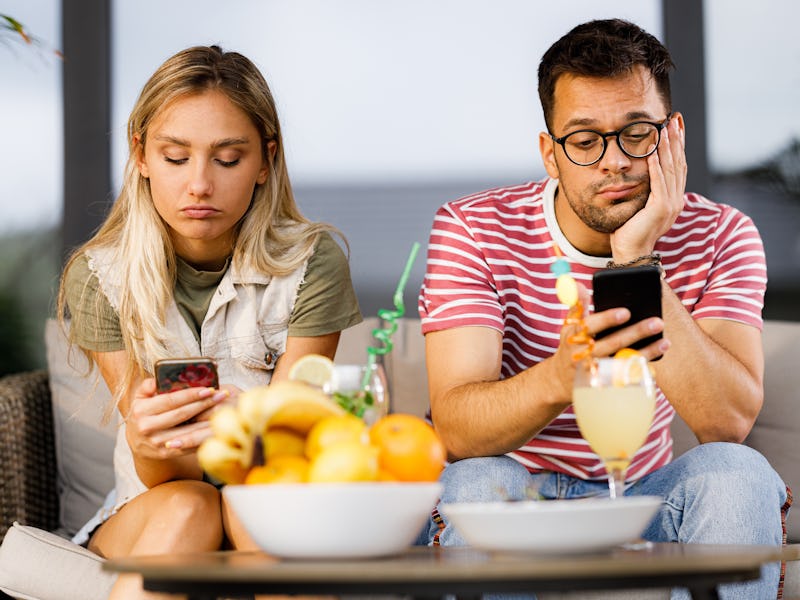 Ignorant couple using their mobile phones while having problems in their relationship.