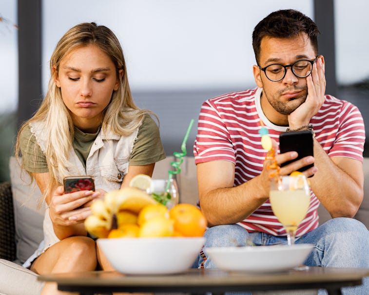 Ignorant couple using their mobile phones while having problems in their relationship.