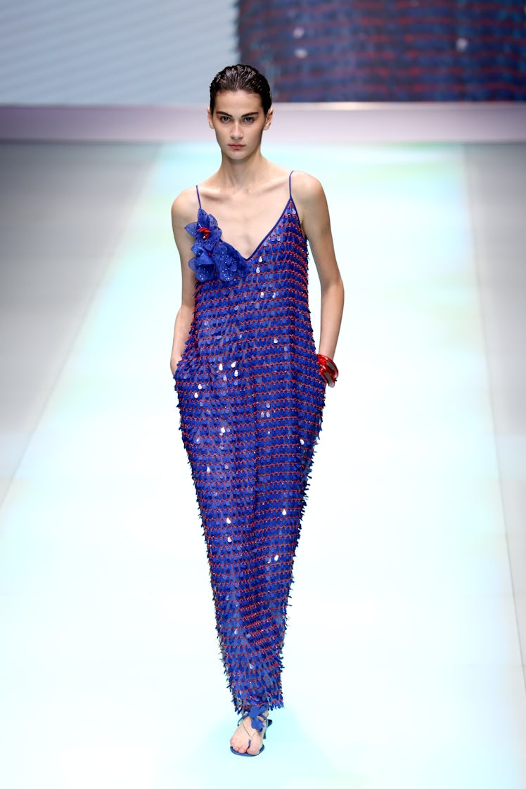 A model at the Emporio Armani fashion show at Milan Fashion Week in a blue, floor-length, shimmery g...