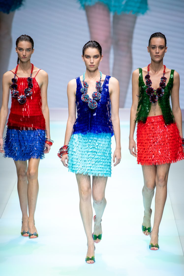Three models at the Emporio Armani fashion show at Milan Fashion Week in shimmery tank tops and skir...