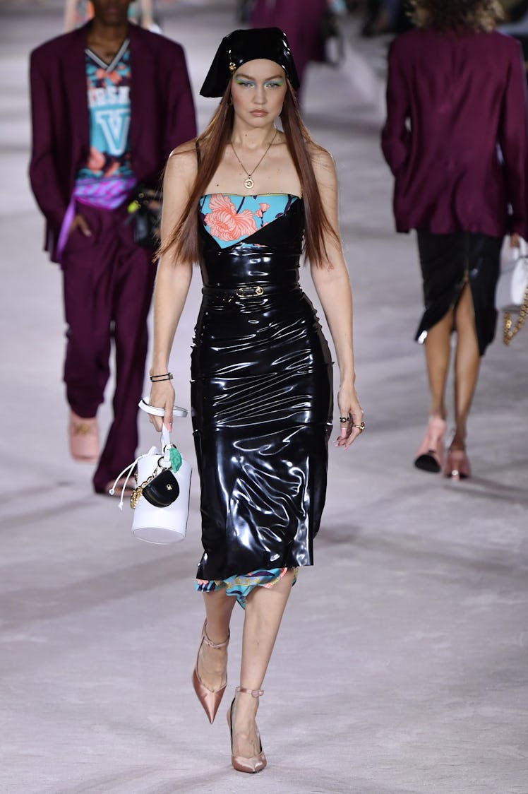 Gigi Hadid on the runway of Versace Ready to Wear Spring/Summer 2022 in a black leather dress with b...