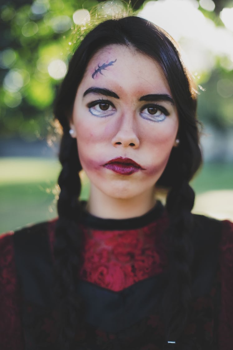 Girl dressed up in doll Halloween eye makeup