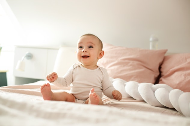 baby girl laughing on bed