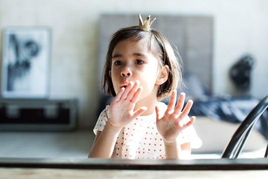 Little girl blowing on wet fingernails