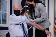 WASHINGTON, DC - SEPTEMBER 27: U.S. President Joe Biden rolls up his sleeve before receiving a third...