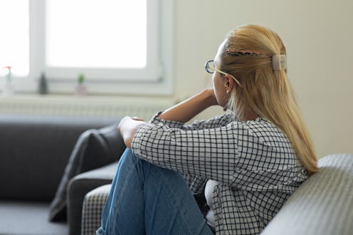 Woman in depression is looking through the window