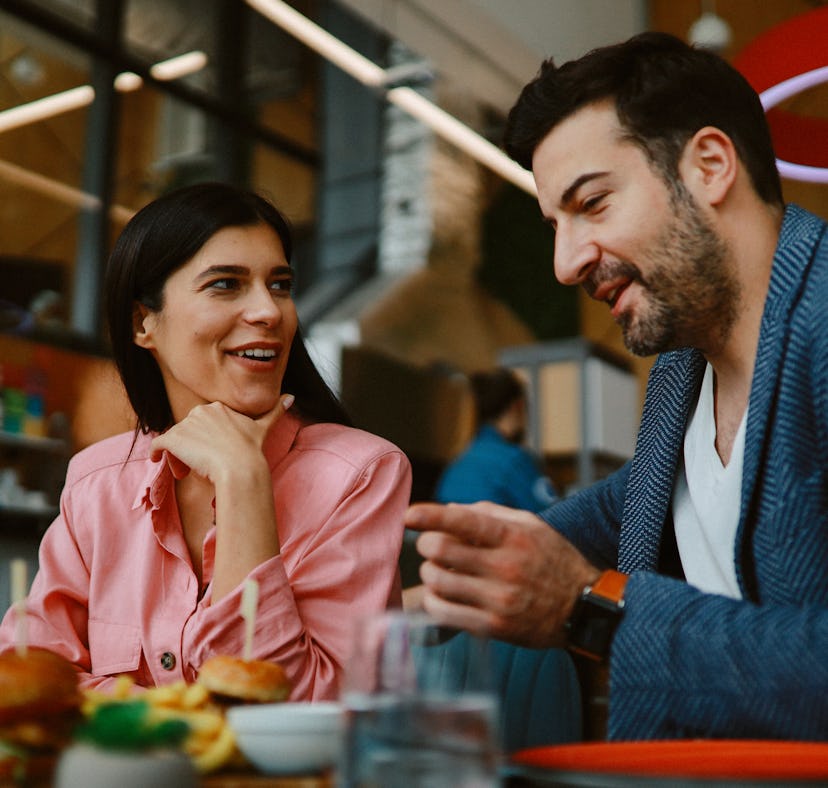 A moon in Virgo man and a woman on a dinner date, talking and eating.