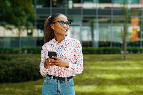 Young African woman in the city using smart phone