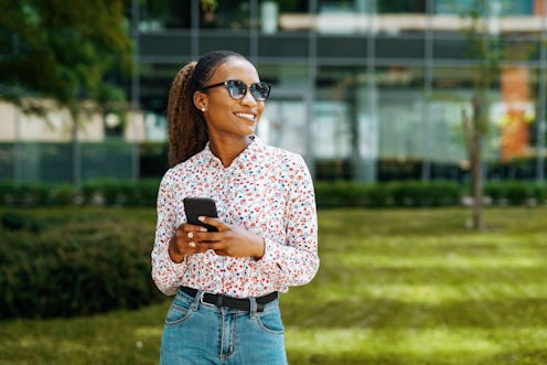 Young African woman in the city using smart phone