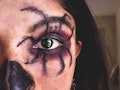 A young woman with a spider Halloween eye makeup look