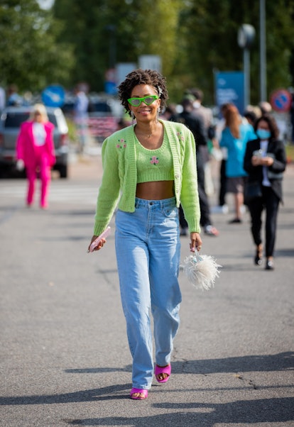 MILAN, ITALY - SEPTEMBER 23: A guest is seen wearing cardigan, cropped top, denim jeans outside Boss...