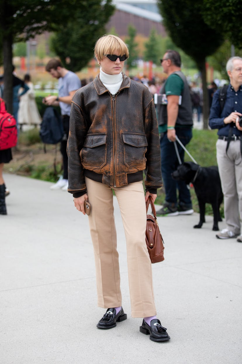 MILAN, ITALY - SEPTEMBER 25: A guest outside MSGM fashion show wearing an aviator jacket during the ...