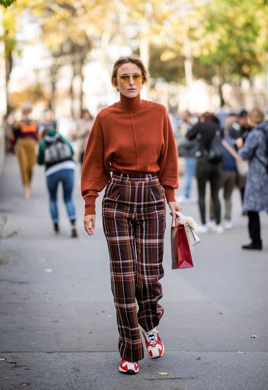 Rebecca Laurey wearing plaid pants, sneaker, knit during Paris Fashion Week.
